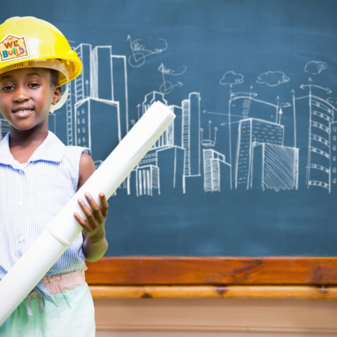 Little,Girl,Wearing,Yellow,Helmet,And,Construction,Plan,Against,Blackboard